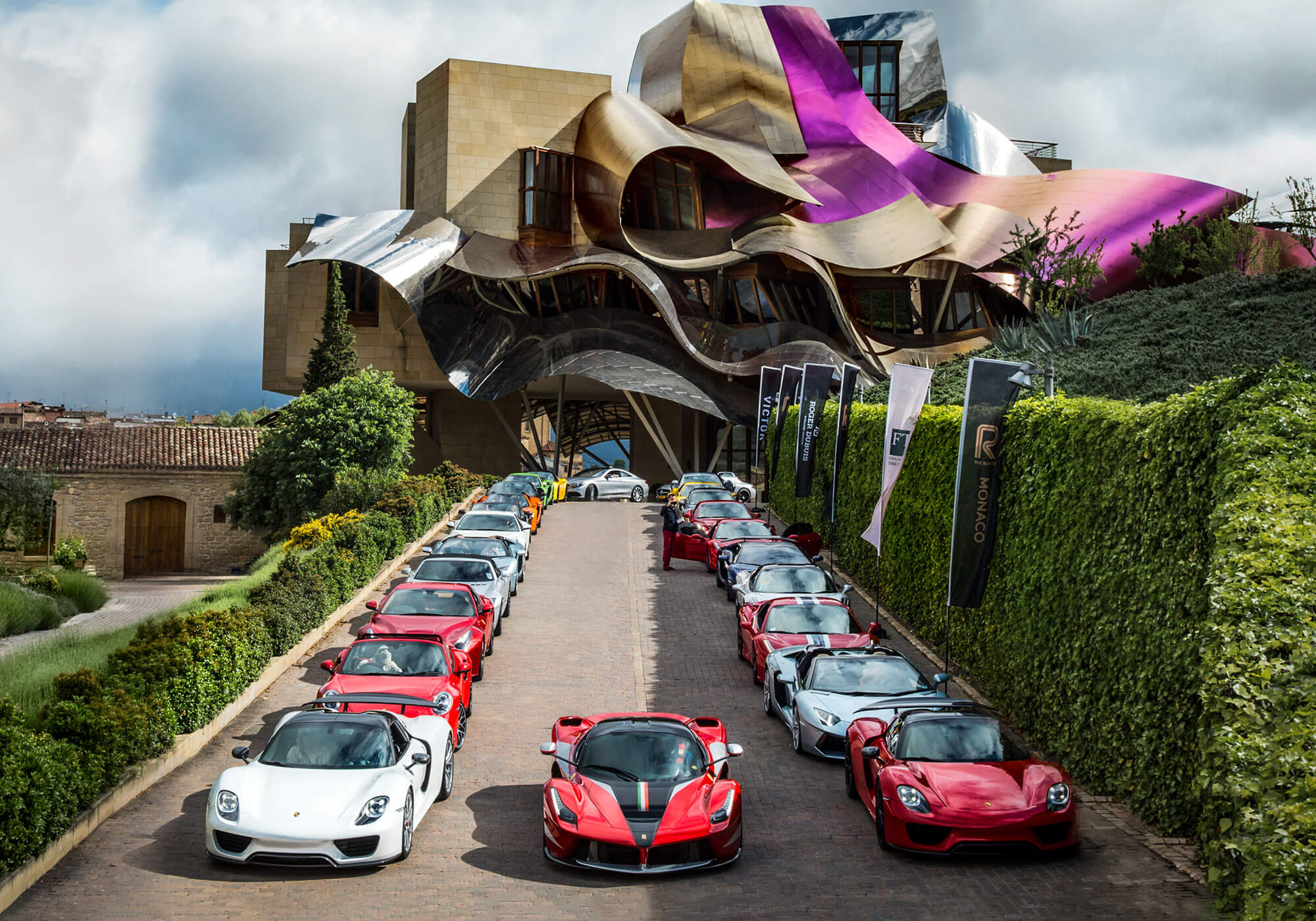 Collection of supercars parked outside Frank Gehry design hotel at Spanish Marques de Riscal Vineyard