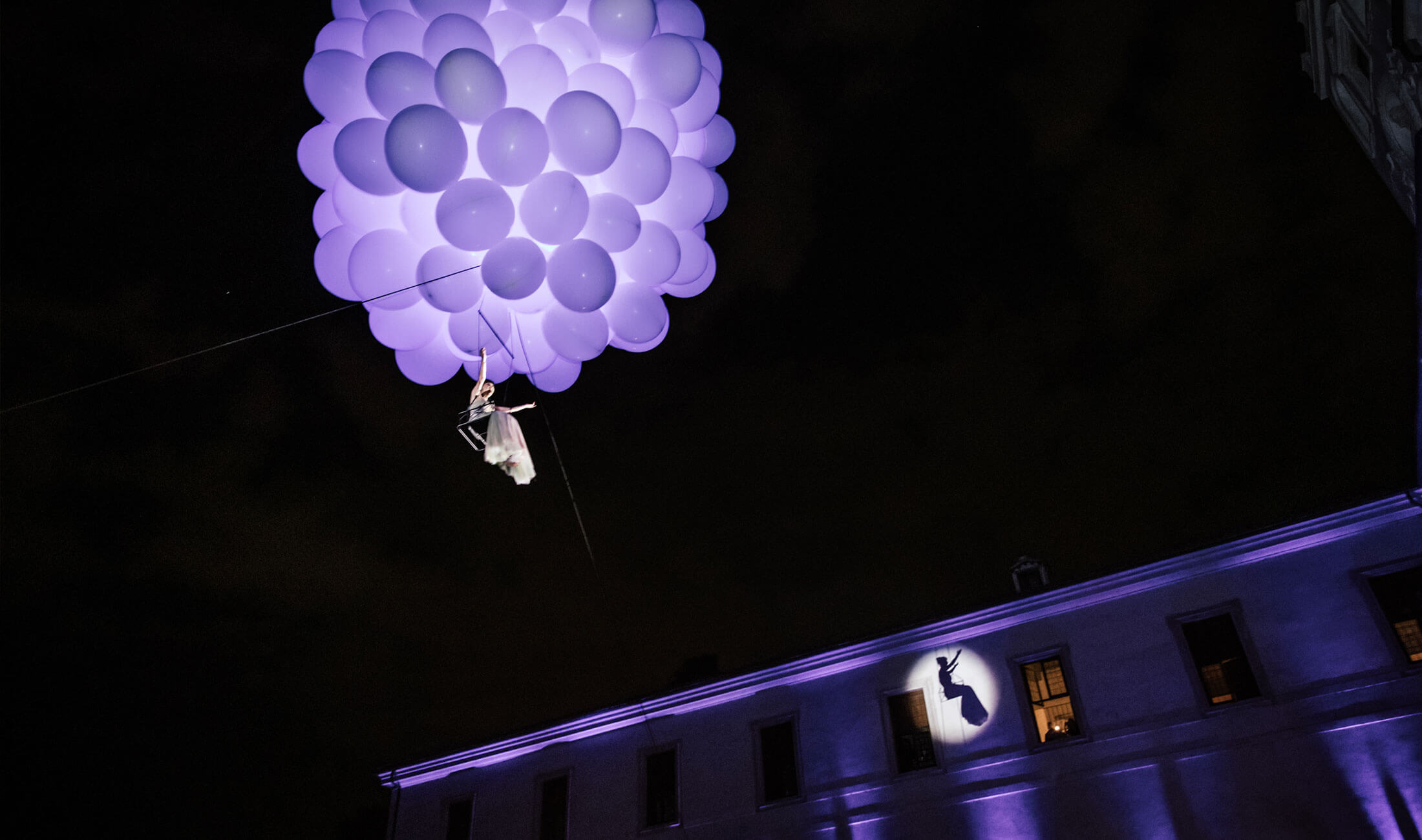 Opera singer suspended by balloons and lit with purple light in Rome