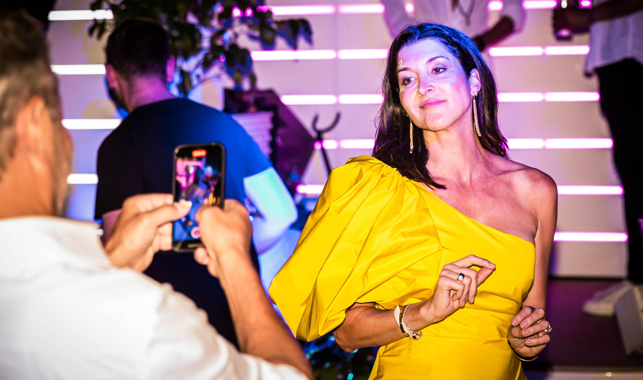Run To guest wearing yellow dress on yacht at party being filmed by guest on phone