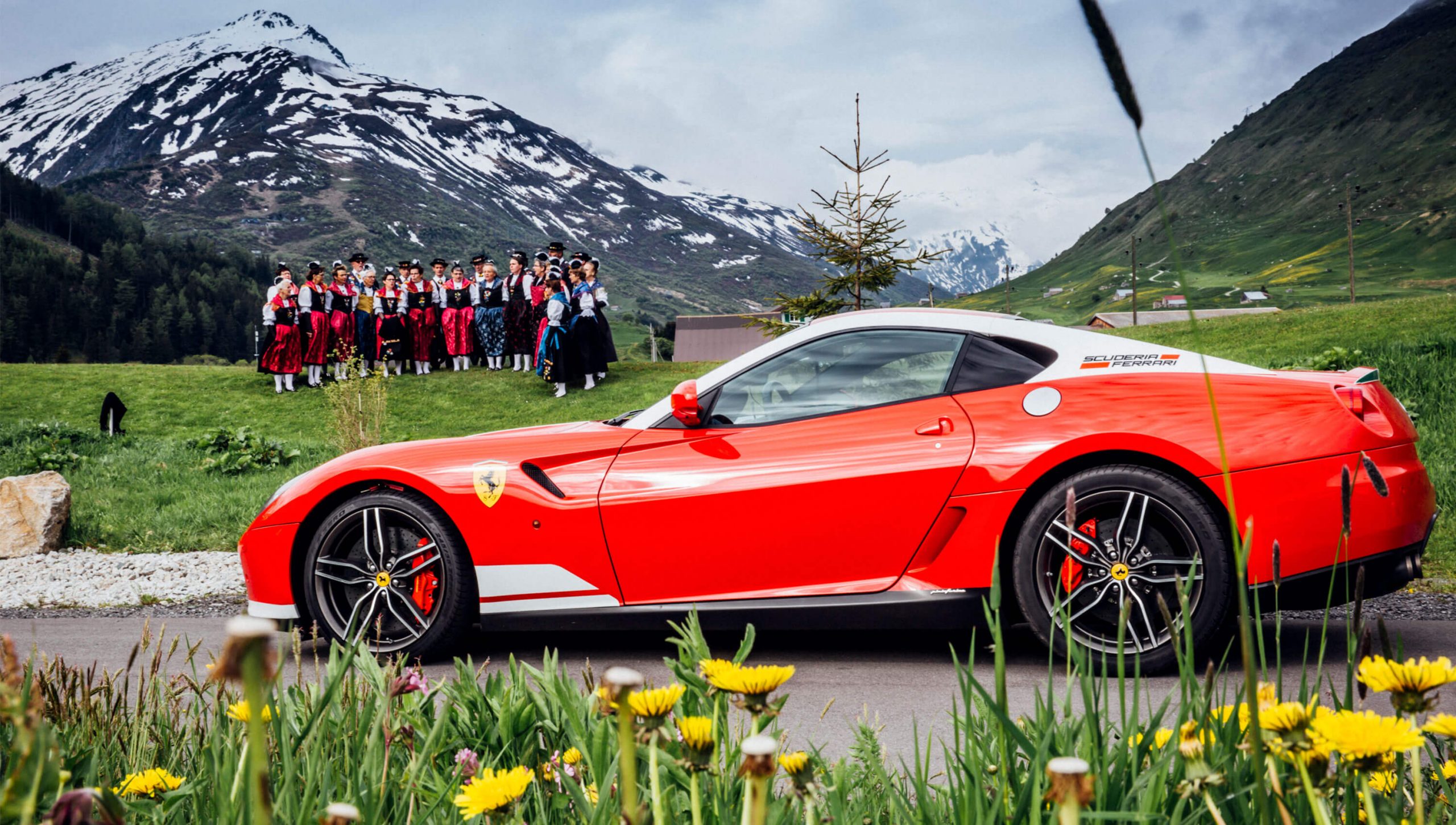 Ferrari in the Swiss Alps alongside traditional Swiss singers