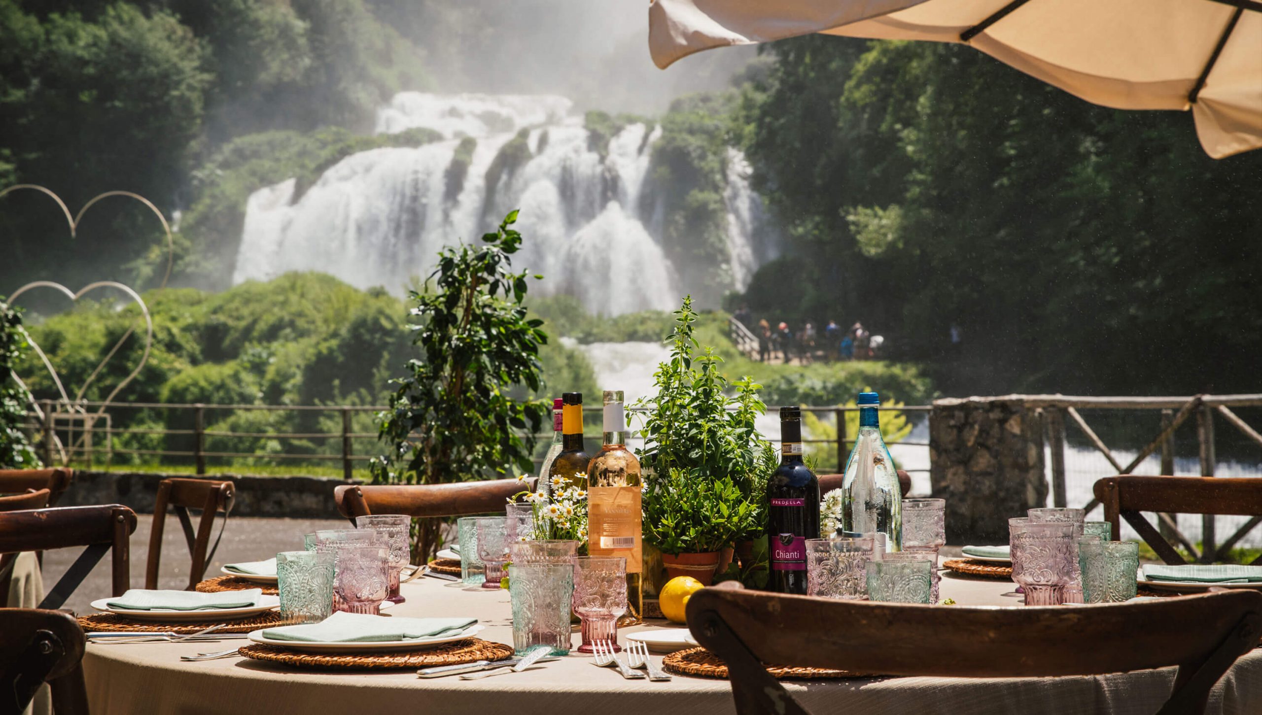 Table set for lunch outside near a waterfall in Tuscany