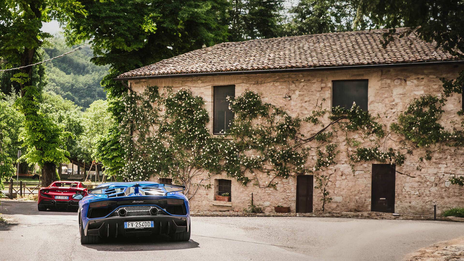 Supercars driving between village properties on a French road